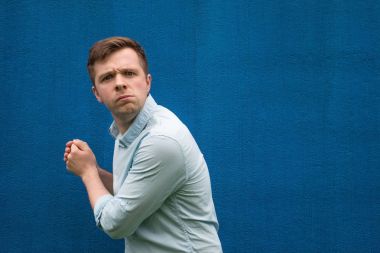 Genç açgözlü biri bir şey elinde gizler ve caddenin ileri görünüyor.