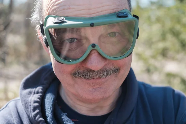 Um homem idoso com bigode e óculos de segurança . — Fotografia de Stock