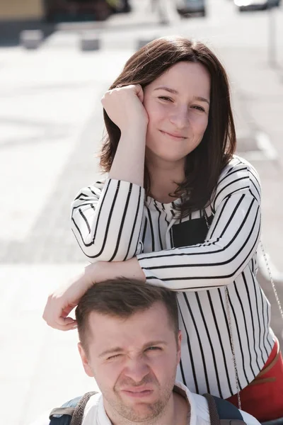 A beautiful girl leaned her shoulders on her best friend's head. The guy is dissatisfied with this. — Stock Photo, Image