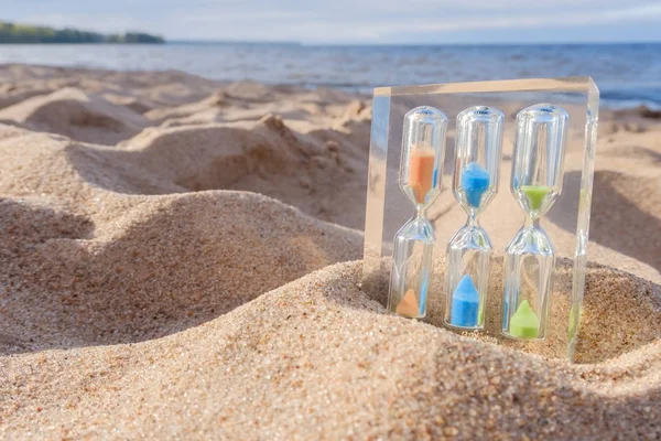 Sand clock on sunny beach