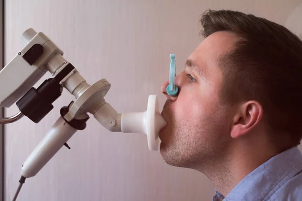 Young man testing breathing function by spirometry — Stock Photo, Image