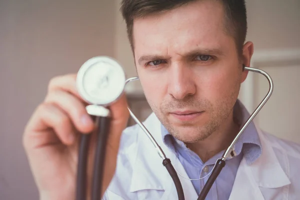 Giovane bel medico che tiene lo stetoscopio, pronto per iniziare il test — Foto Stock