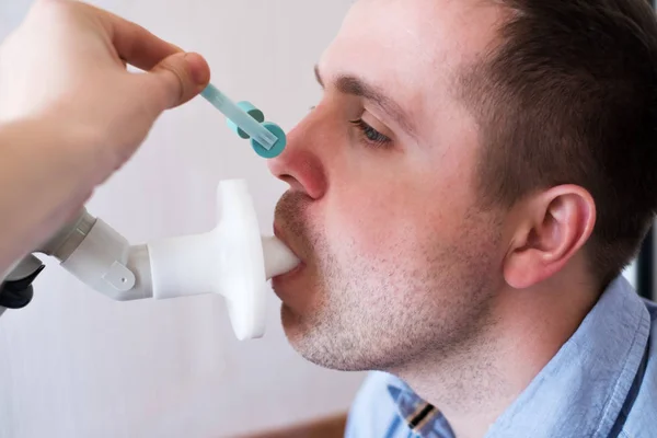 Junger Mann testet Atemfunktion durch Spirometrie. — Stockfoto