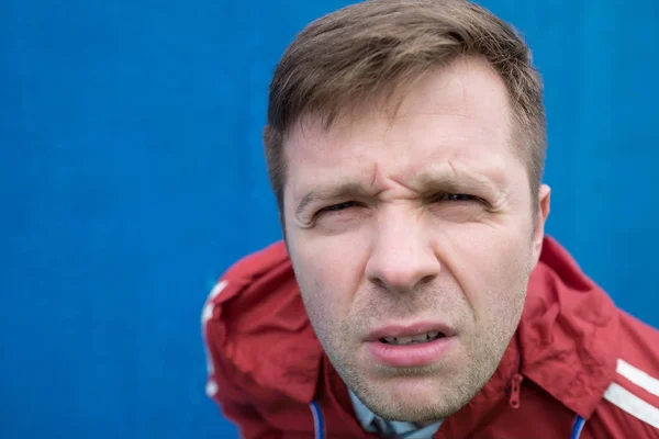 Angry man in red coat looking up — Stock Photo, Image