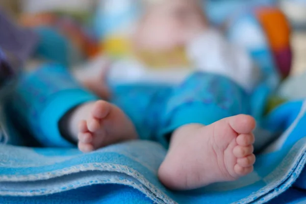 Pés de bebê recém-nascidos em uma toalha azul — Fotografia de Stock