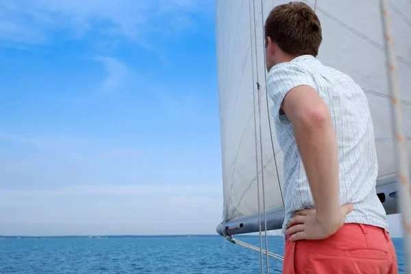 Joven marinero caucásico relajándose felizmente en yate de vela. Se aparta y sueña . — Foto de Stock