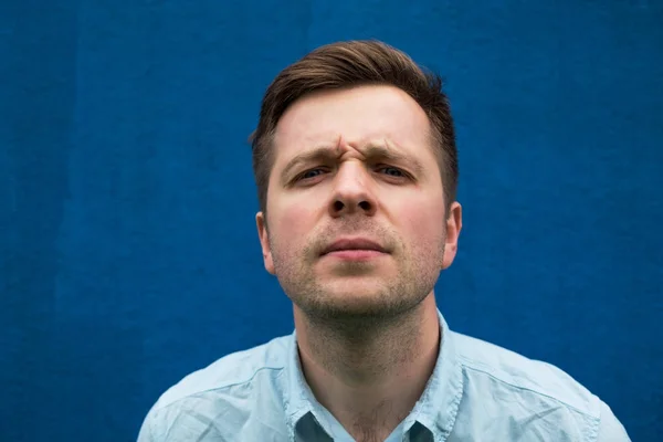 Portret van de jonge Kaukasische man op zoek verward in de camera. — Stockfoto