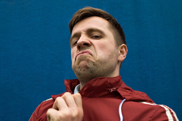 Portrait of caucasian young man with negative emotion on face
