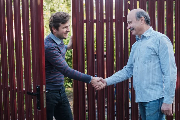 Dos granjeros dándose la mano y tomándose el uno al otro — Foto de Stock