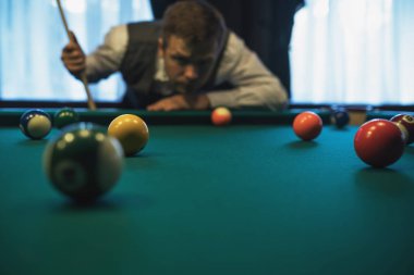 Beyaz delikanlı çekime hazır bilardo oynarken.