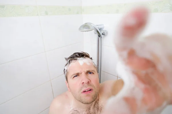 Un giovane caucasico si fa una doccia e nota una telecamera nascosta . — Foto Stock