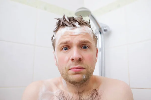 Preoccupato caucasico schiumato giovane dopo che l'acqua sotto la doccia è stata spenta, guardando la fotocamera . — Foto Stock