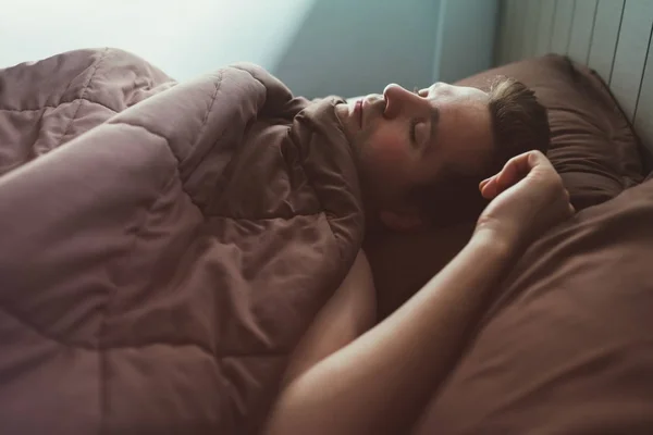 Homem caucasiano cochilando na cama pela manhã . — Fotografia de Stock