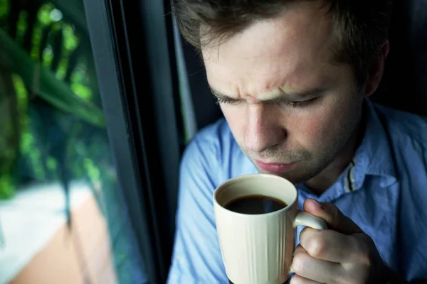 Närbild porträtt av affärsmannen dricker kaffe. man ser tråg fönster och innehav cup — Stockfoto