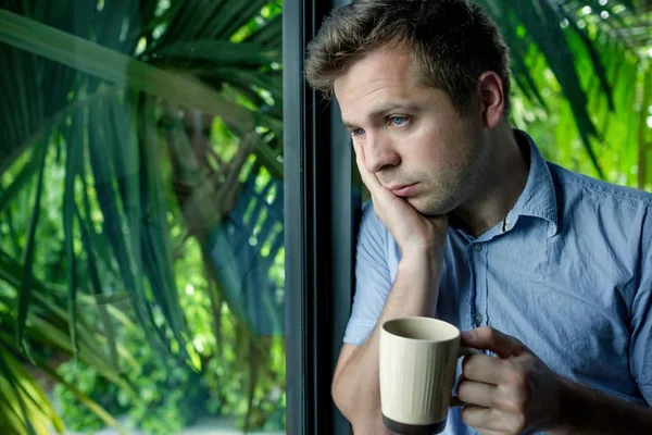 Gros plan portrait d'un homme d'affaires buvant du café. homme regardant par la fenêtre creuse et tenant tasse — Photo