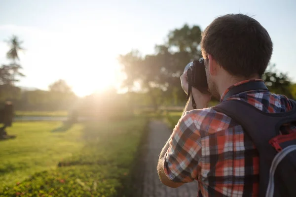 Człowiek fotografowania zachodu słońca na jego profesjonalnych aparatów fotograficznych — Zdjęcie stockowe