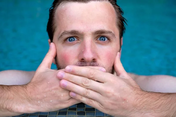 L'uomo è scioccato dalle notizie. Sta chiudendo la bocca. Sta nuotando in piscina durante le vacanze — Foto Stock