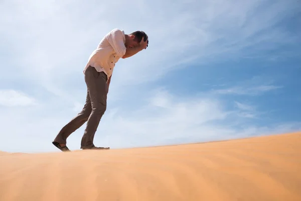 Hombre caminando solo en el desierto soleado. Está perdido y sin aliento. Sin agua y energía . — Foto de Stock