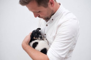 Küçük bir köpek yavrusu onun elinde tutan adam