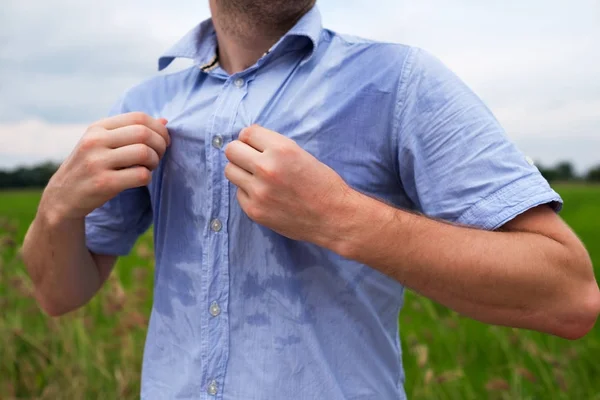 Hombre con hiperhidrosis sudando muy mal bajo la axila en camisa azul, aislado en gris —  Fotos de Stock