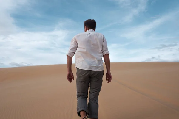 Caucásico joven va derecho en su camino en el desierto de arena — Foto de Stock