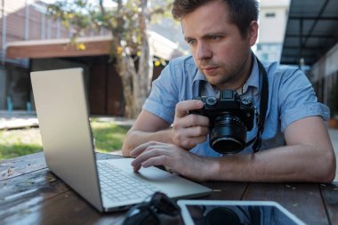 Beyaz genç adam fotoğrafçı dışarıda fotoğraf düzenleme