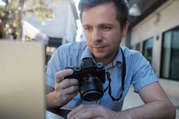 Kaukaski mężczyzna młody fotograf jest edytowanie zdjęć siedział zewnątrz — Zdjęcie stockowe