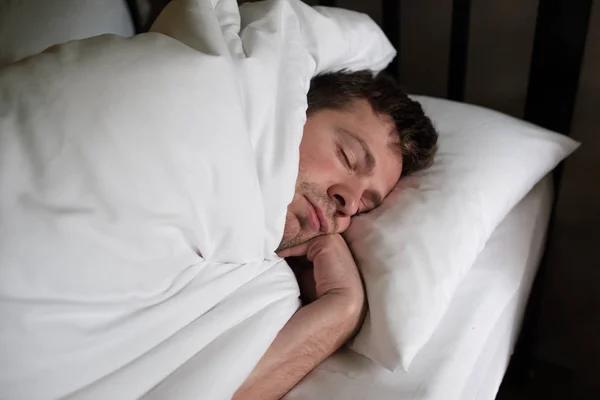 Pria kaukasia tidur atau tidur siang di tempat tidur putih — Stok Foto