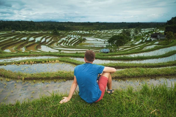 Jovem Viajante sentado e relaxante ao ar livre em campos de arroz em terraço em Bali Indonesia . — Fotografia de Stock