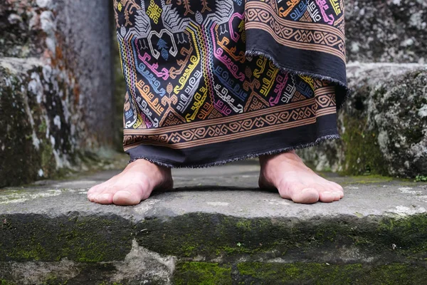 Закрыть вид на человеческую ногу в балийском индонансе и саронге . — стоковое фото