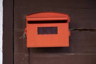 Kahverengi tahta arka plan ile kırmızı posta kutusu.