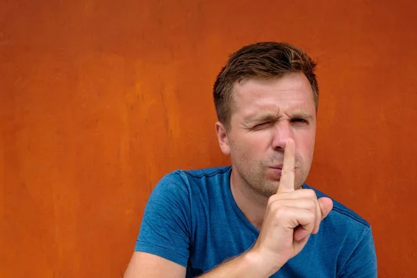 Retrato de close-up de jovem caucasiano colocando o dedo nos lábios como se dissesse, shh, fique quieto — Fotografia de Stock