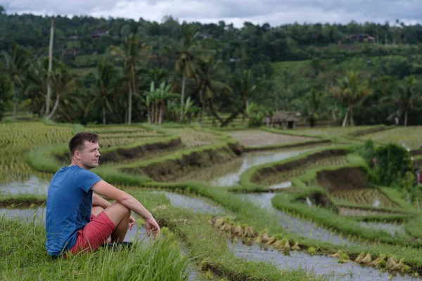 Jovem Viajante sentado e relaxante ao ar livre em campos de arroz em terraço em Bali Indonesia . — Fotografia de Stock