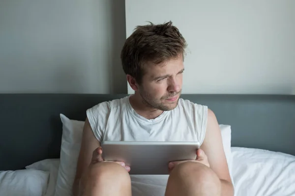 Aantrekkelijke Kaukasische jonge man met behulp van Tablet PC in bed in de ochtend — Stockfoto