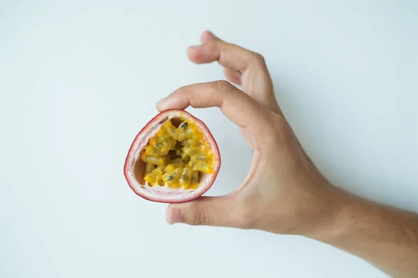 Hand of caucasian woman holding juicy passion fruit — Stock Photo, Image