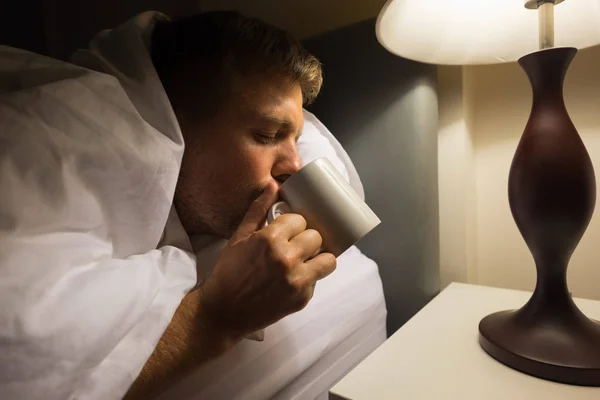 Pria dewasa berpenyakit Kaukasia meminum air di tempat tidur di malam hari. . — Stok Foto