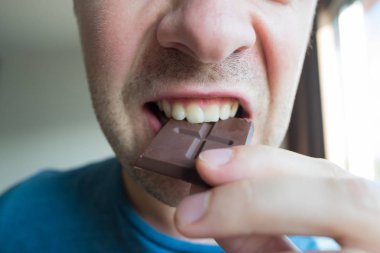 Yalnız bir çikolata yeme genç beyaz adam