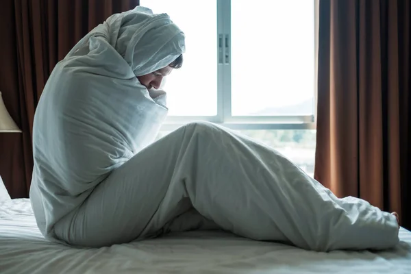 Deprimerad man som sitter på sin säng täckt med filt och titta på fönstret. Han är deprimerad efter skilsmässa — Stockfoto