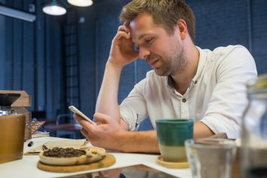 Kafede tek başına oturmak ve arkadaşları bekliyor beyaz adam.