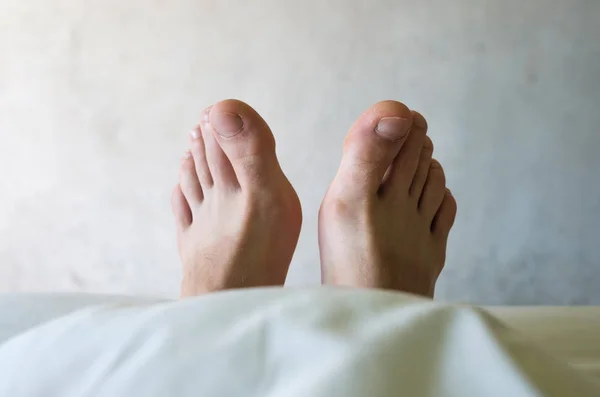 Кавказский мужчина ноги на кровати — стоковое фото