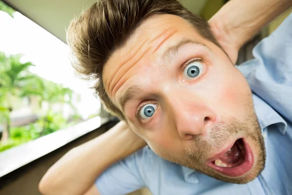 Panic man is shocked. His face is close to camera. He is opening his mouth in surprise — Stock Photo, Image