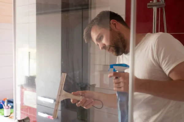 Kaukasischer Mann putzt seine Duschkabine zu Hause — Stockfoto