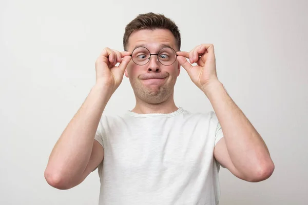 Giovane uomo europeo in occhiali guardando sul naso . — Foto Stock