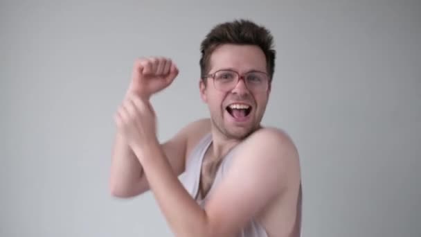 Молодий щасливий п'яний чоловік в окулярах танцює після вечірки . — стокове відео