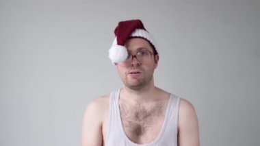 Noel Baba şapkalı ve büyük gözlüklü üzgün beyaz adam.