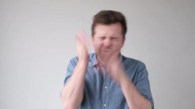 Genç çılgın adam kendi yüzüne vuruyor ve elleriyle kendini cezalandırıyor..