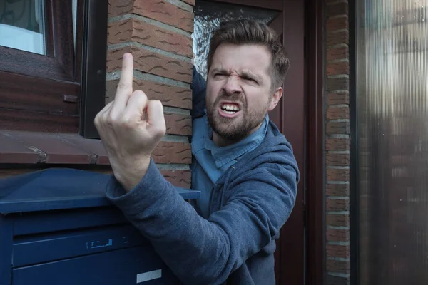 Мужчина сосед показывает ебать тебя жест, кричать стоя возле двери . — стоковое фото