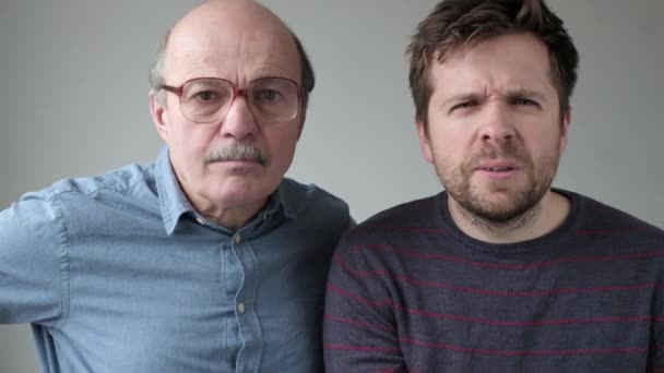 Emotivering volwassen vader en zoon hebben geschokte gezichten. — Stockvideo