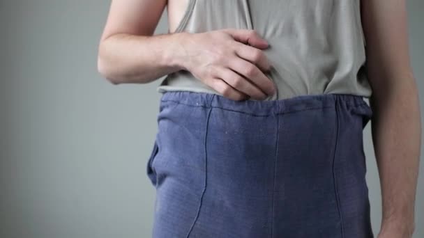 Schlecht gekleideter Mann kratzt sich am Bauch — Stockvideo