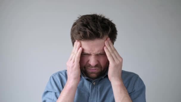 Joven que sufre de dolor de cabeza severo, presionando los dedos en las sienes, cerrando los ojos para aliviar el dolor . — Vídeos de Stock